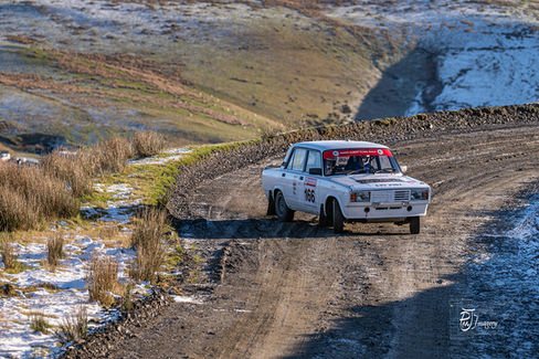 White coloured rally car on gravel track competing in Roger Albert Clark Rally