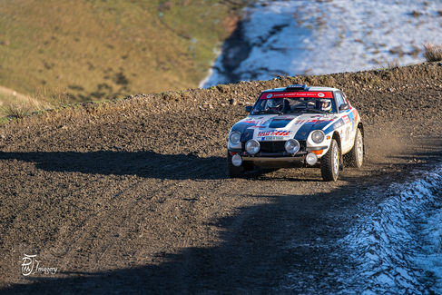 Datsun 240z rally car on gravel track competing in Roger Albert Clark Rally
