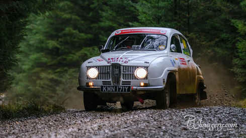 Rally car on gravel road in the forest.