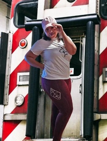 Beautiful woman wearing Team Get Fit LLC merchandise standing on the caboose of a train