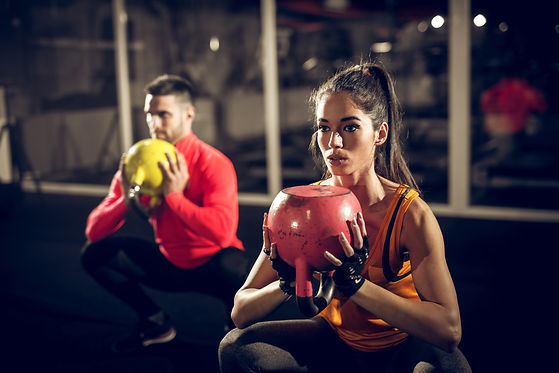 Close up of focused and motivated strong young fitness couple in sportswear crouching with