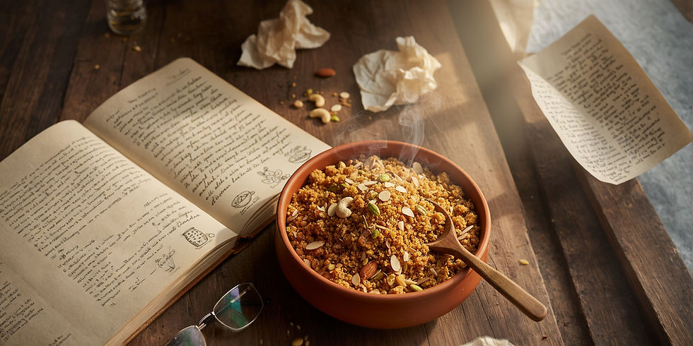 A cozy kitchen scene where a steaming bowl of freshly prepared panjeeri with nuts invites the viewer, set beside handwritten recipes in an open cookbook, creating a warm ambiance of tradition and home cooking.