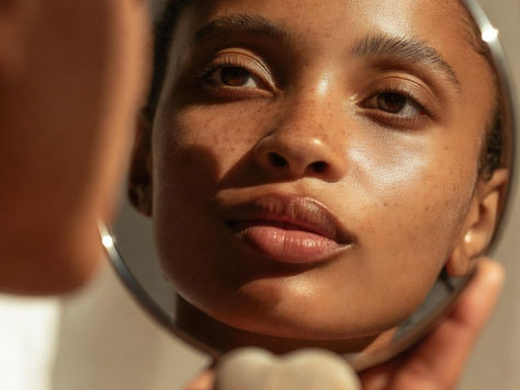 Eine Frau die in einen kleinen Handspiegel ihr inneres reflecktiert