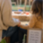 Parent and child sitting together in a nature-based preschool setting with a handwritten note that says, “I’m coming back after snack time,” reinforcing a predictable preschool dropoff routine
