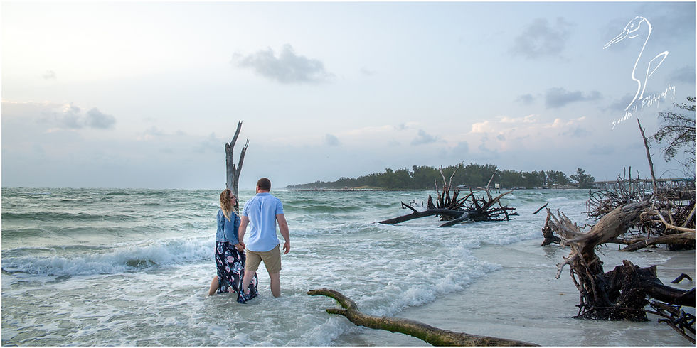 Longboat Key Engagement Photographer, couple walking down the beach through the waves at beer can island