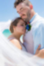 Sarasota Wedding Photographer, the newly weds share a moment to embrace and relax after their tropical beach wedding ceremony