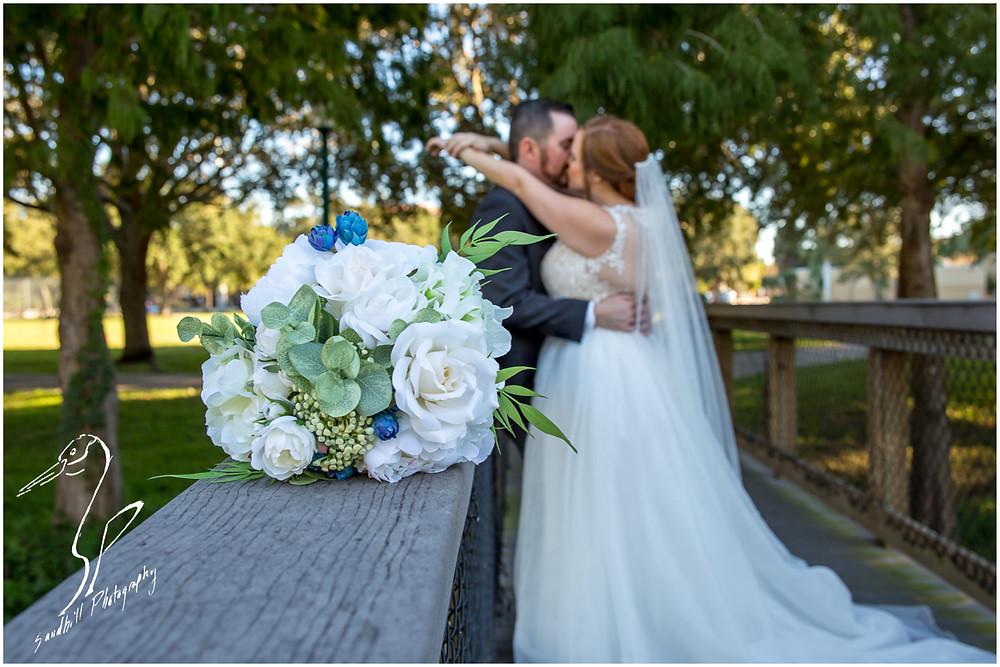 Sarasota Wedding Photography picture of the bridal bouquet with the bride and groom kissing in background