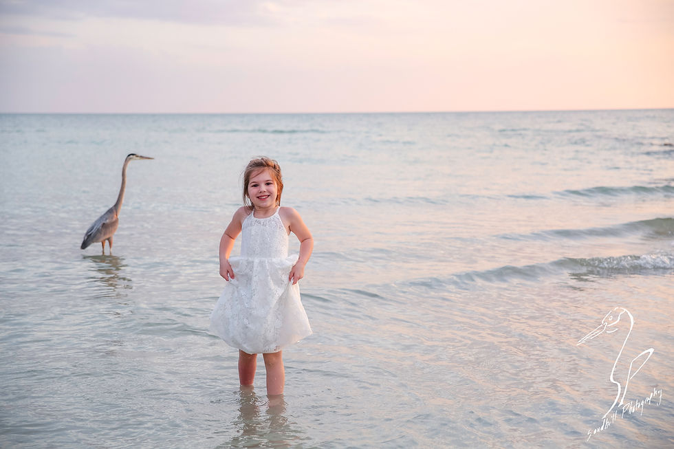 Bradenton Family Photographer | Top 10 tips for Pictures with Kids, girl lifts her dress while standing in the water