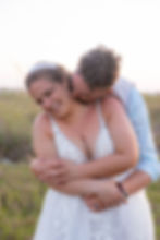 Sarasota Wedding Photographer groom kisses brides neck as they embrace by the beach
