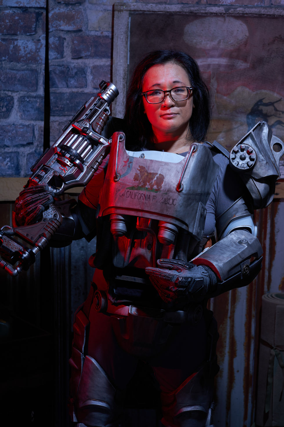 Person in futuristic armor holding a large weapon.