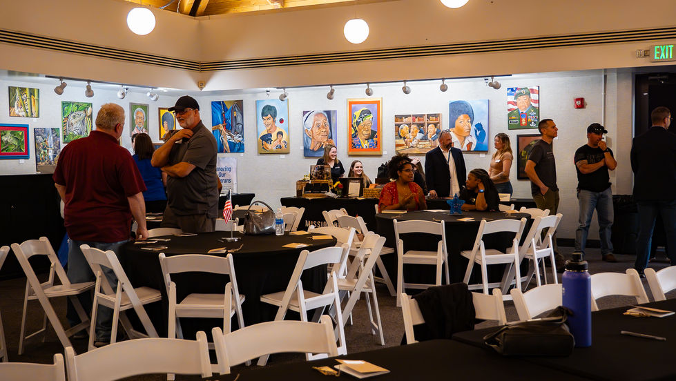 Art gallery event with people and paintings displayed.