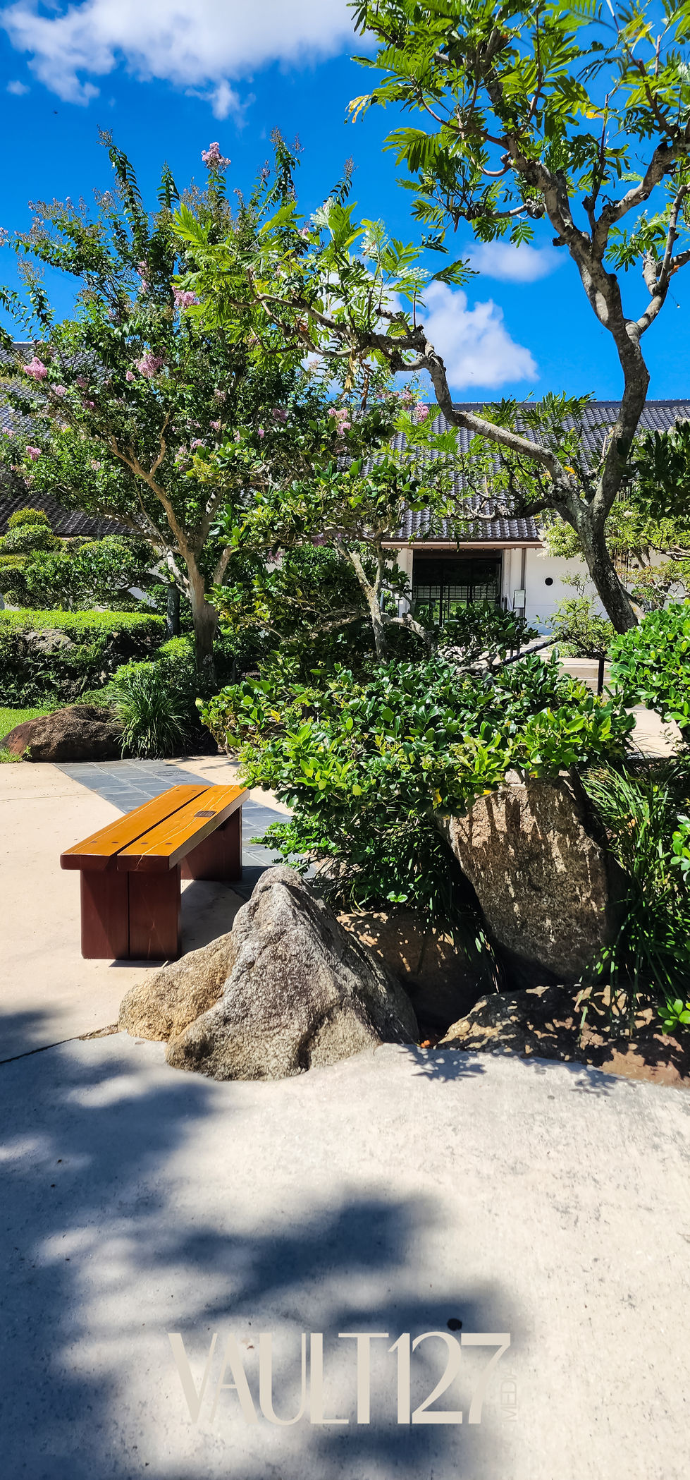 Garden with bench and large rocks.