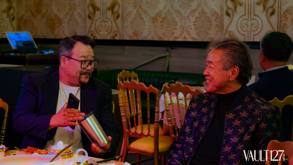 Two people smiling and talking at a dining table.