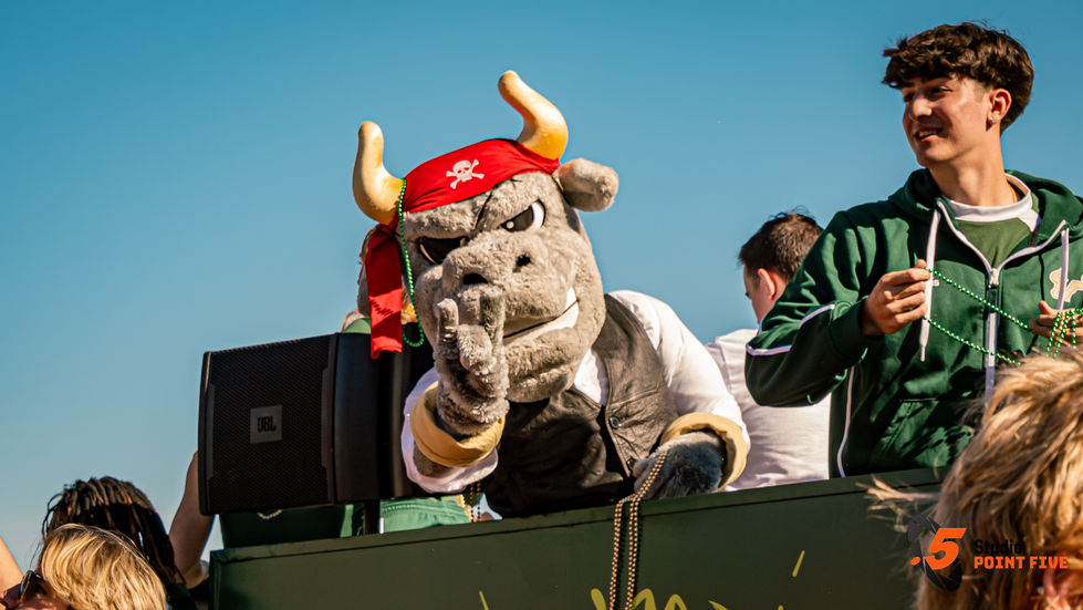 Mascot in pirate attire pointing at camera.