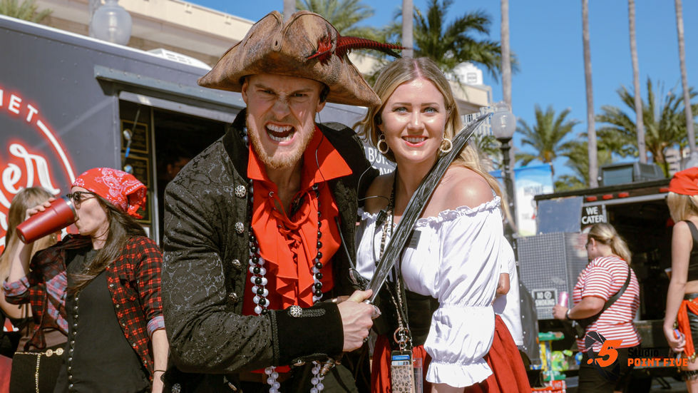 Pirate-themed duo posing with sword and smiles.