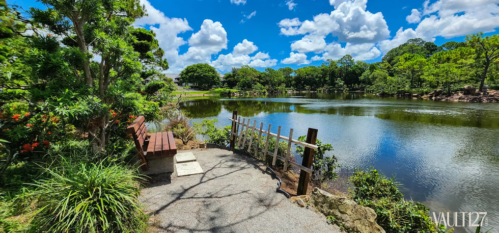 Park bench overlooking a serene lake and trees.