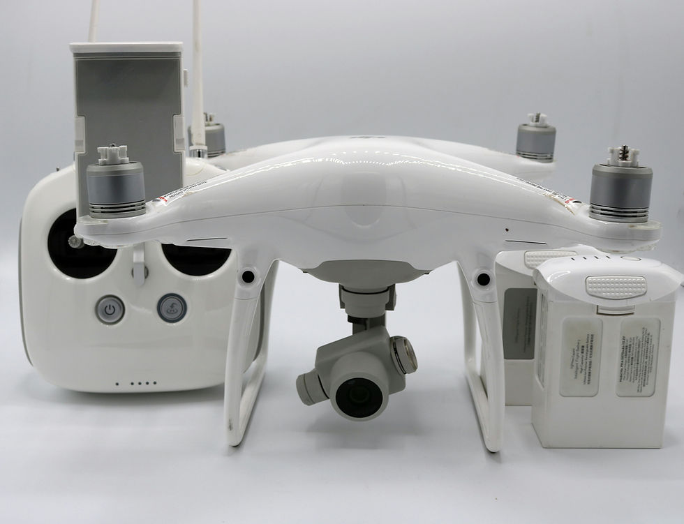 White drone with camera, remote control, and batteries on a white background. The setup is clean and technology-focused.