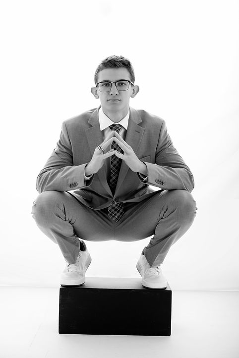 High school senior boy portrait grey suit plaid tie glasses crouching black block black and white Melody Smith Portrait Studio Petersburg VA serving Richmond Virginia