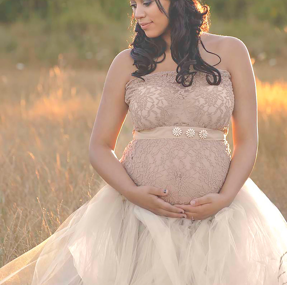 "Expectant mother basking in the warm sunlight of a serene outdoor maternity photo shoot."

