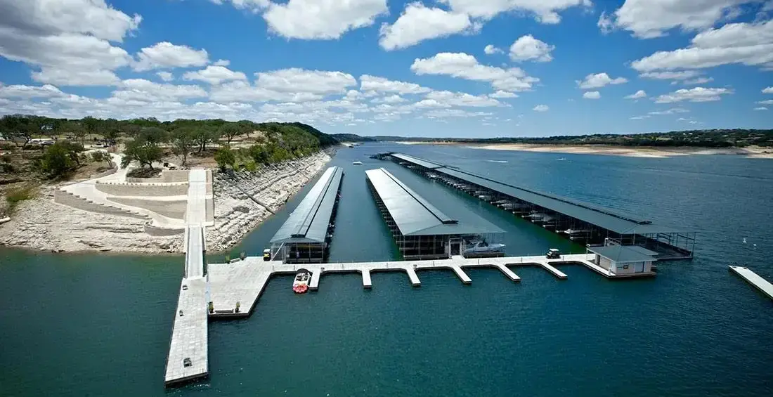 a photo of concrete retaining walls with a golf cart path leading to a floating concrete marina structure