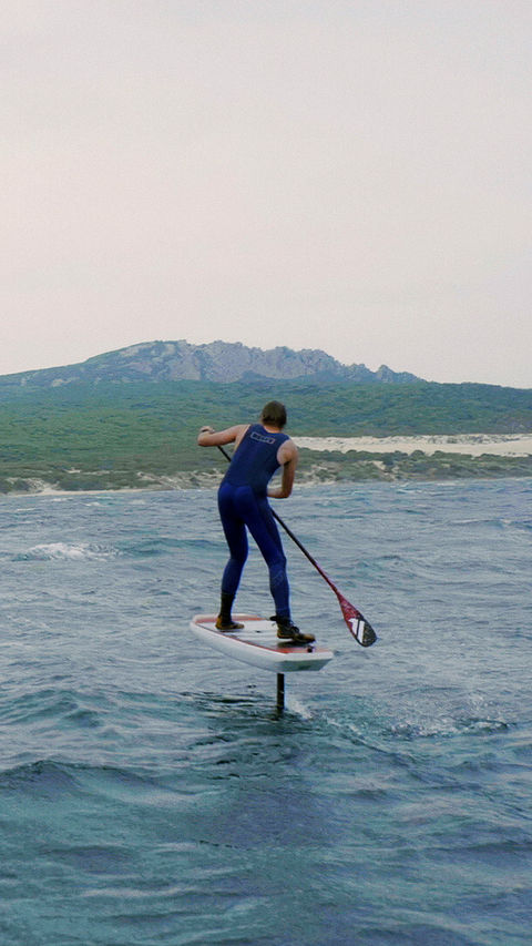 Windsurfer Fred Bonnef riding across the Strait of Gibraltar with sea and mountains in background.