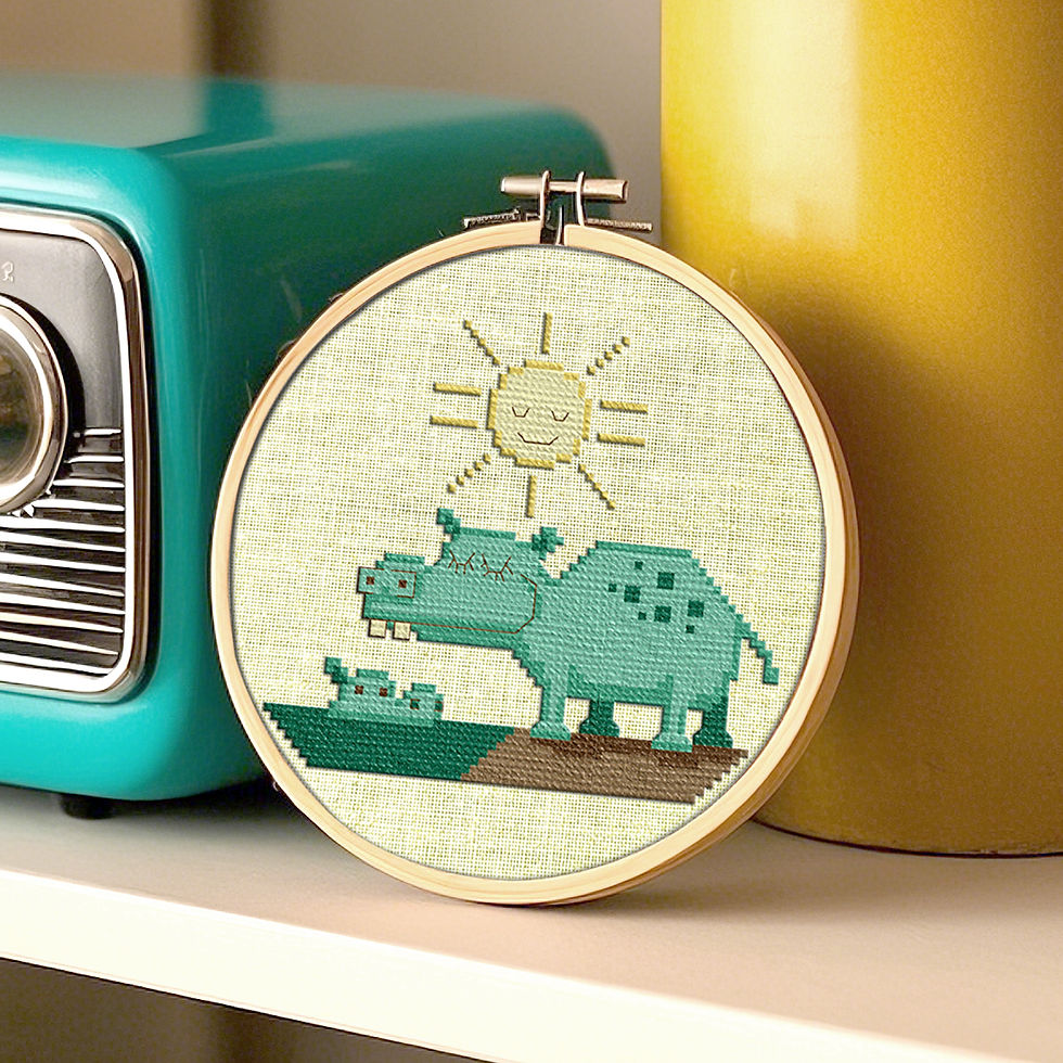 A vintage hippo mama and baby counted cross stitch pattern displayed next to a retro radio and vase