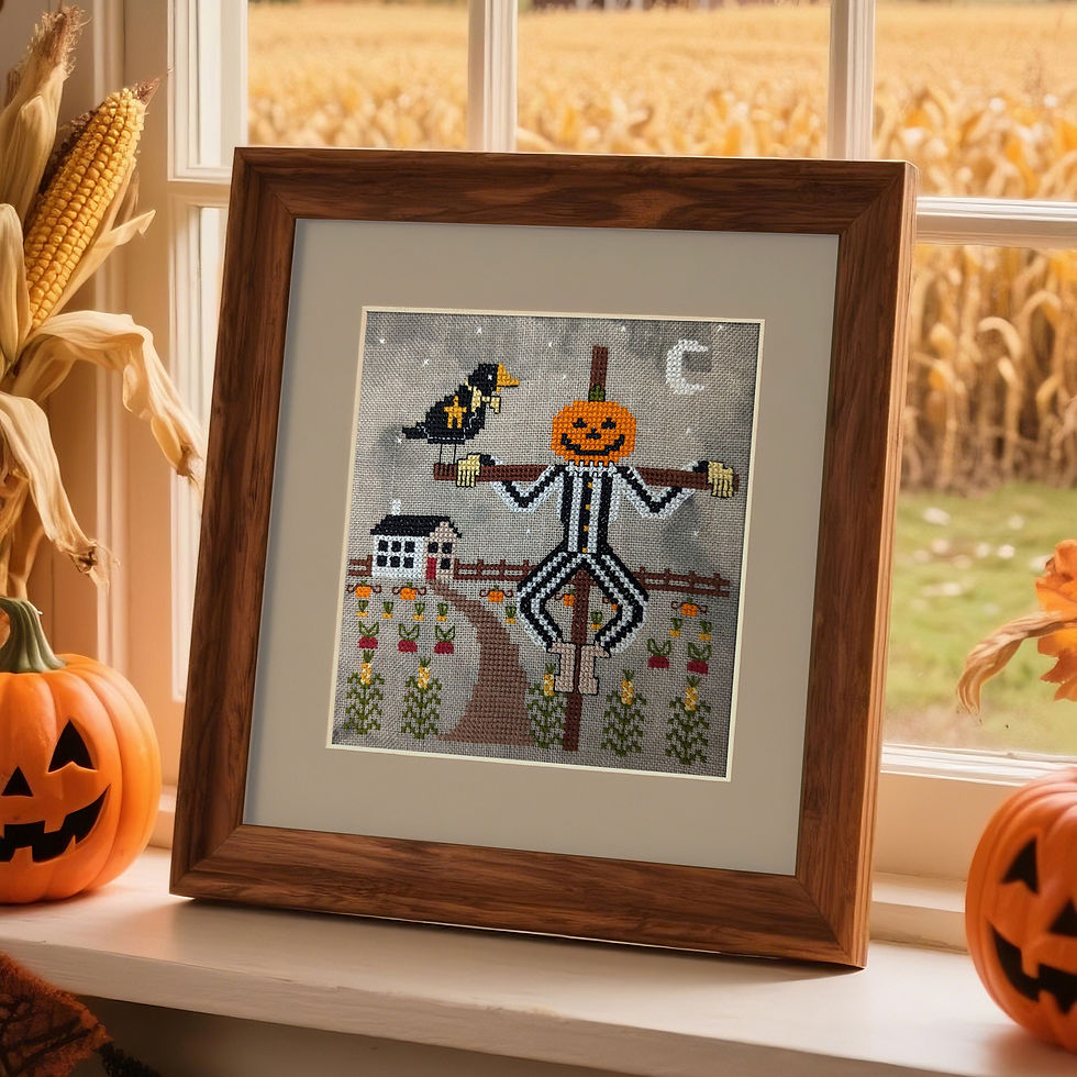 A cross stitch pattern of a pumpkin headed scarecrow and crow framed and displayed on the windowsill of a country farmhouse