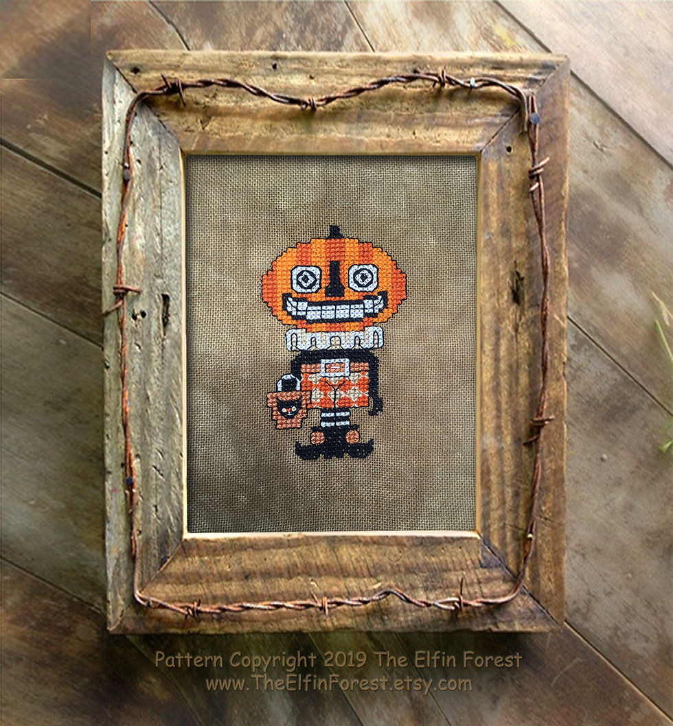 Thumbnail: A needlepoint pumpkin head jack o’ lantern Halloween primitive counted cross stitch pattern in a rustic frame