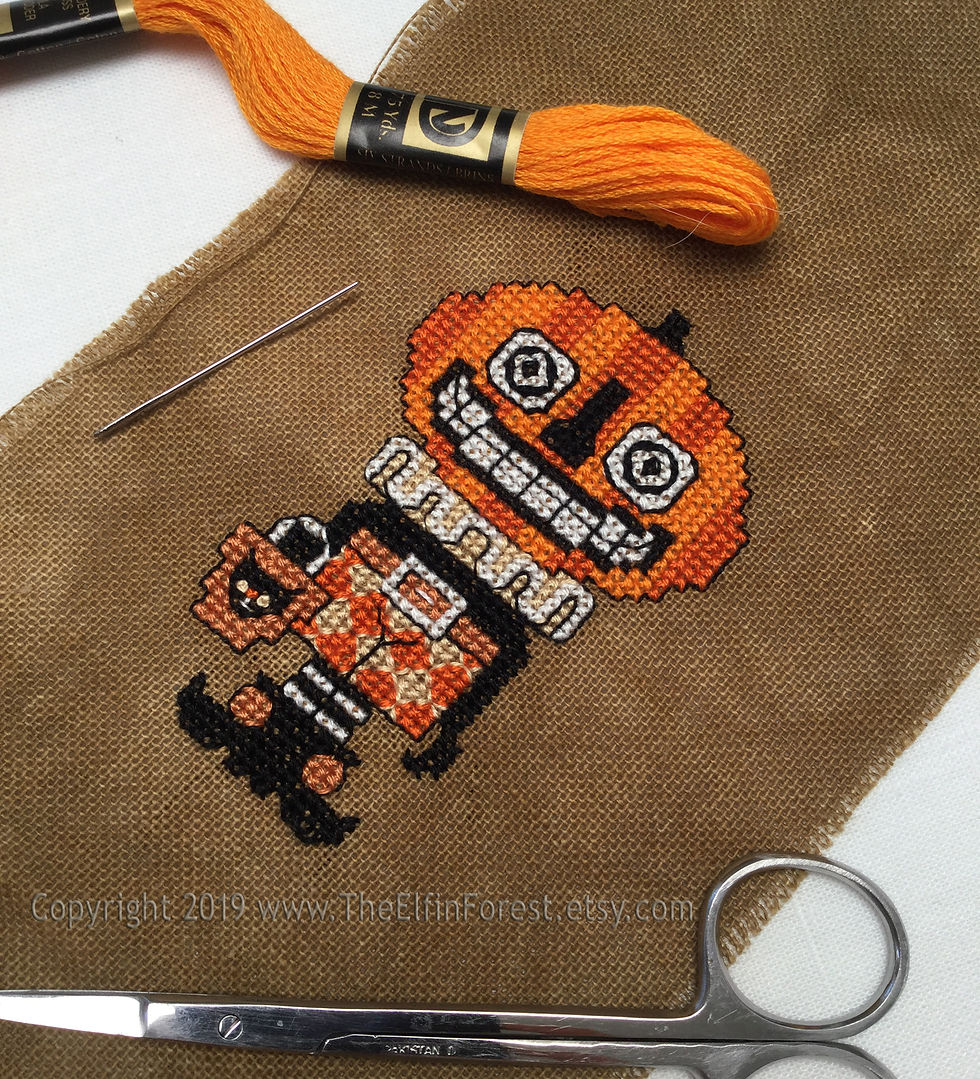 Thumbnail: Embroidered pumpkin head jack o’ lantern Halloween folk counted cross stitch pattern on brown linen