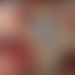 a person cutting strawberries to decorate pudding in a teacup