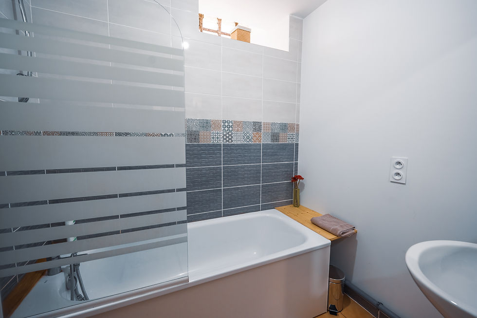 Grande salle de bain lumineuse avec baignoire, moderne et décor élégant, idéale pour un moment de dé