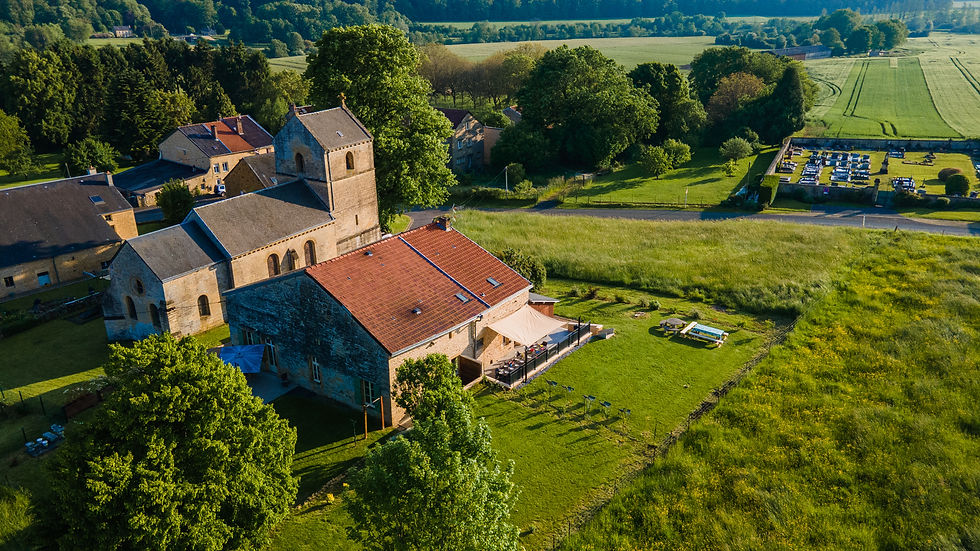 Vue extérieure des gîtes, entouré de verdure dans la campagne des Ardennes