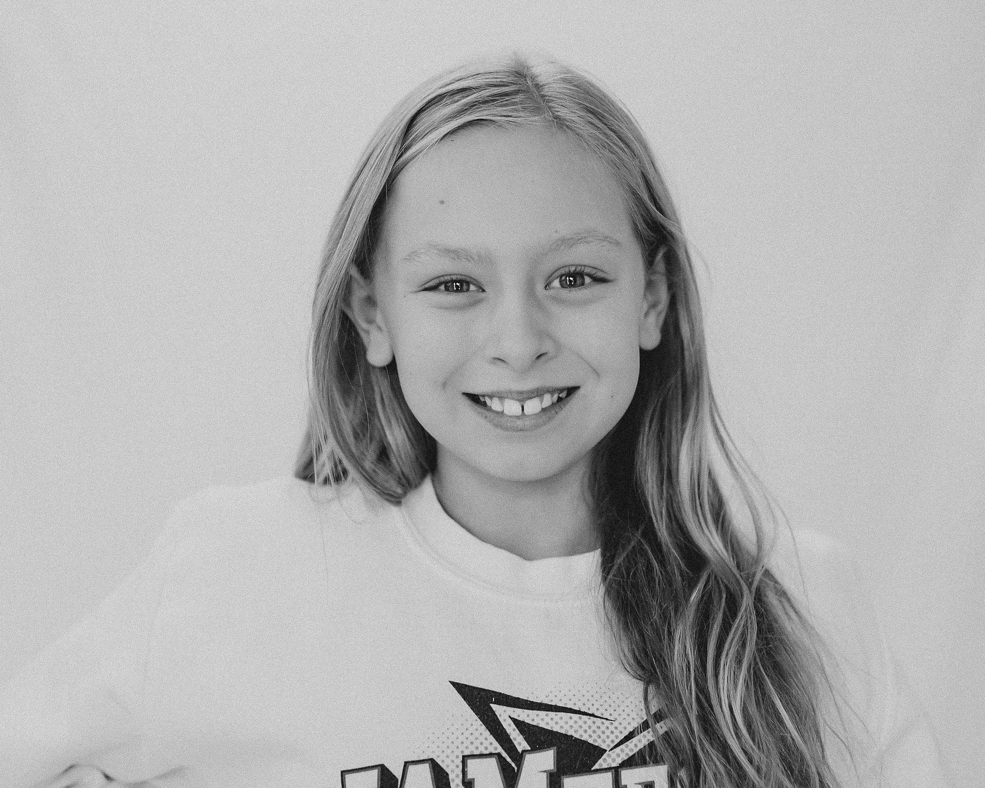 girl with long blonde hair looking at camera posing for black and white portrait
