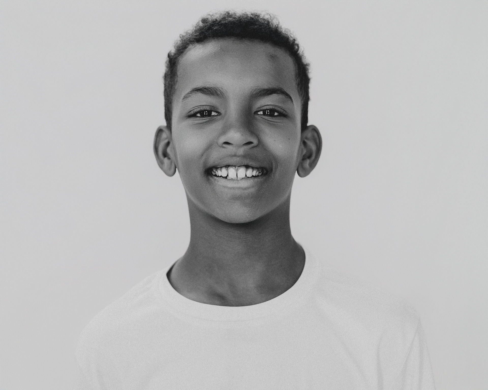 Boy looking at camera in solid background and black and white image