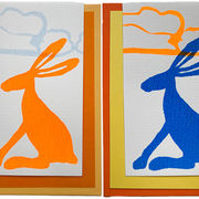 sitzender oranger oder blauer Hase vor einer Wolke