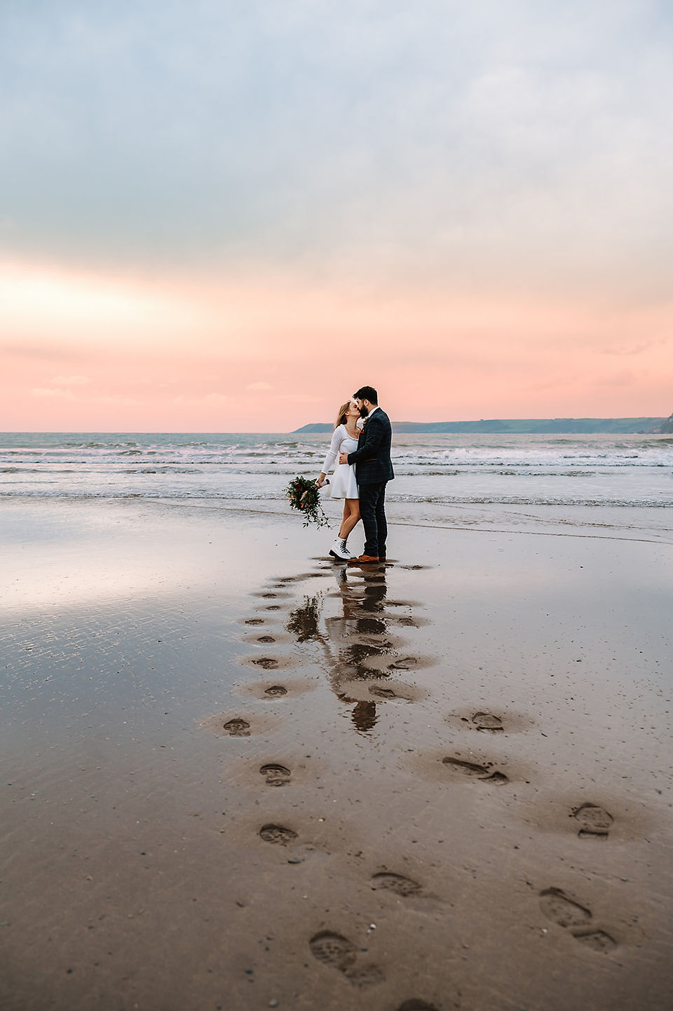 Lovers kiss infront of  the sunset on the beach in Devon