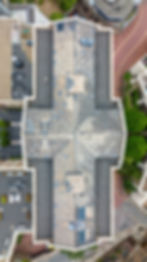 An aerial photo looking down an inspecting a damaged roof.