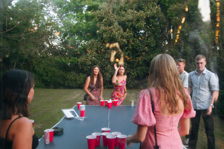 Friends playing a game of beer-pong at a birthday party. High energy, Cambridge, New Zealand