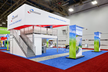 Double-deck trade show exhibit with demo stations and meeting areas