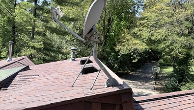 Old satellite dish mounted on an asphalt shingle roof in Madison, Wisconsin
