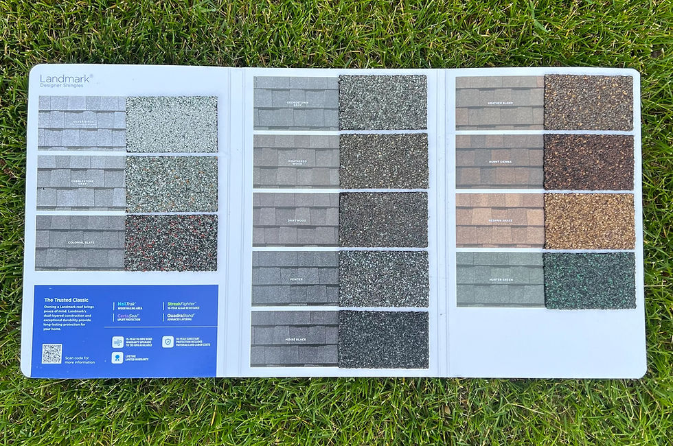 shingle sample board from CertainTeed’s Landmark® line, showing a variety of asphalt shingle colors in natural daylight on green grass. The samples include popular shades like Charcoal Black, Weathered Wood, Driftwood, and Moire Black, giving homeowners a real-world look at how the colors appear outside.