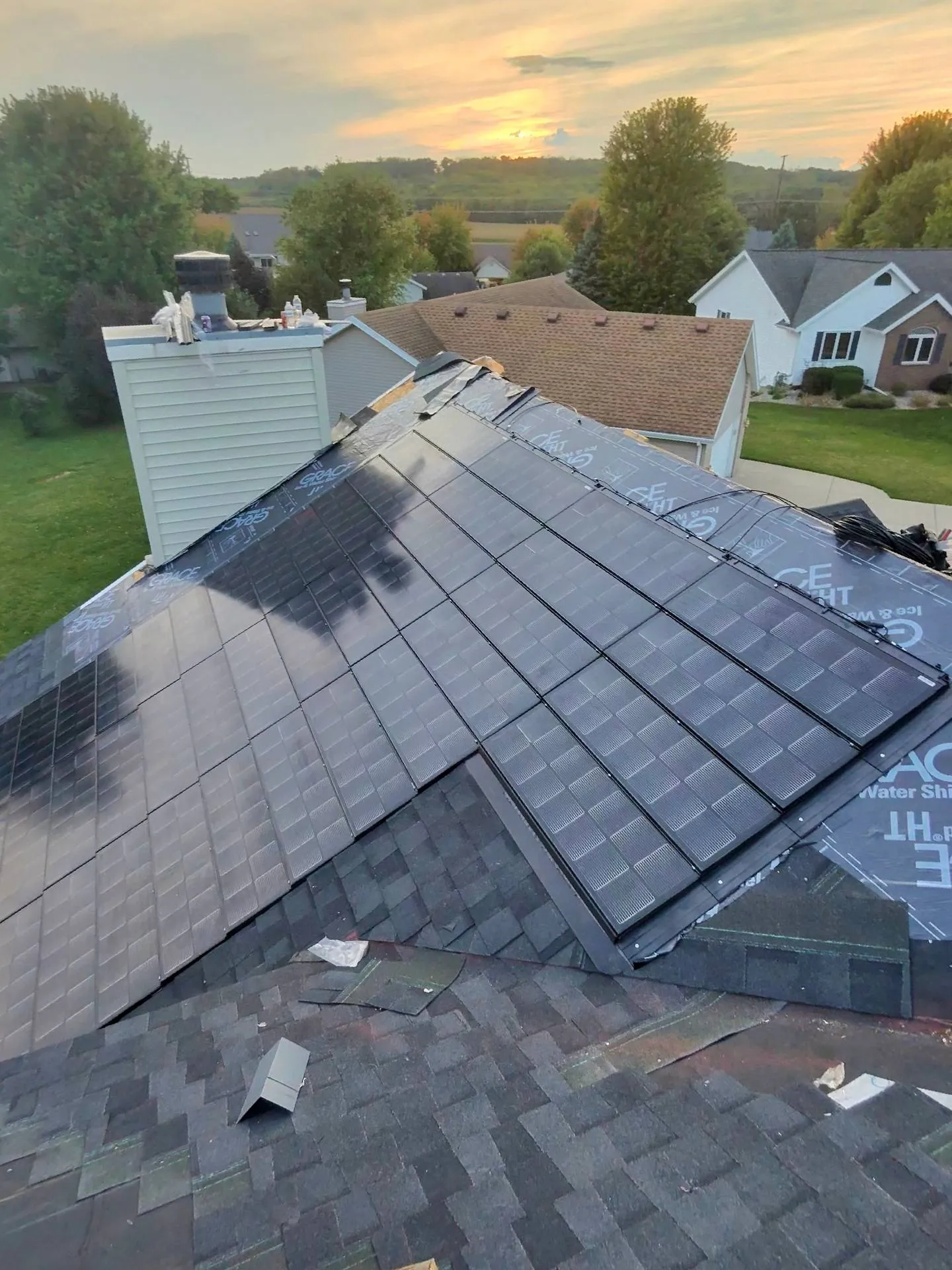 Solstise solar shingle installation looking down from across roof to sunset