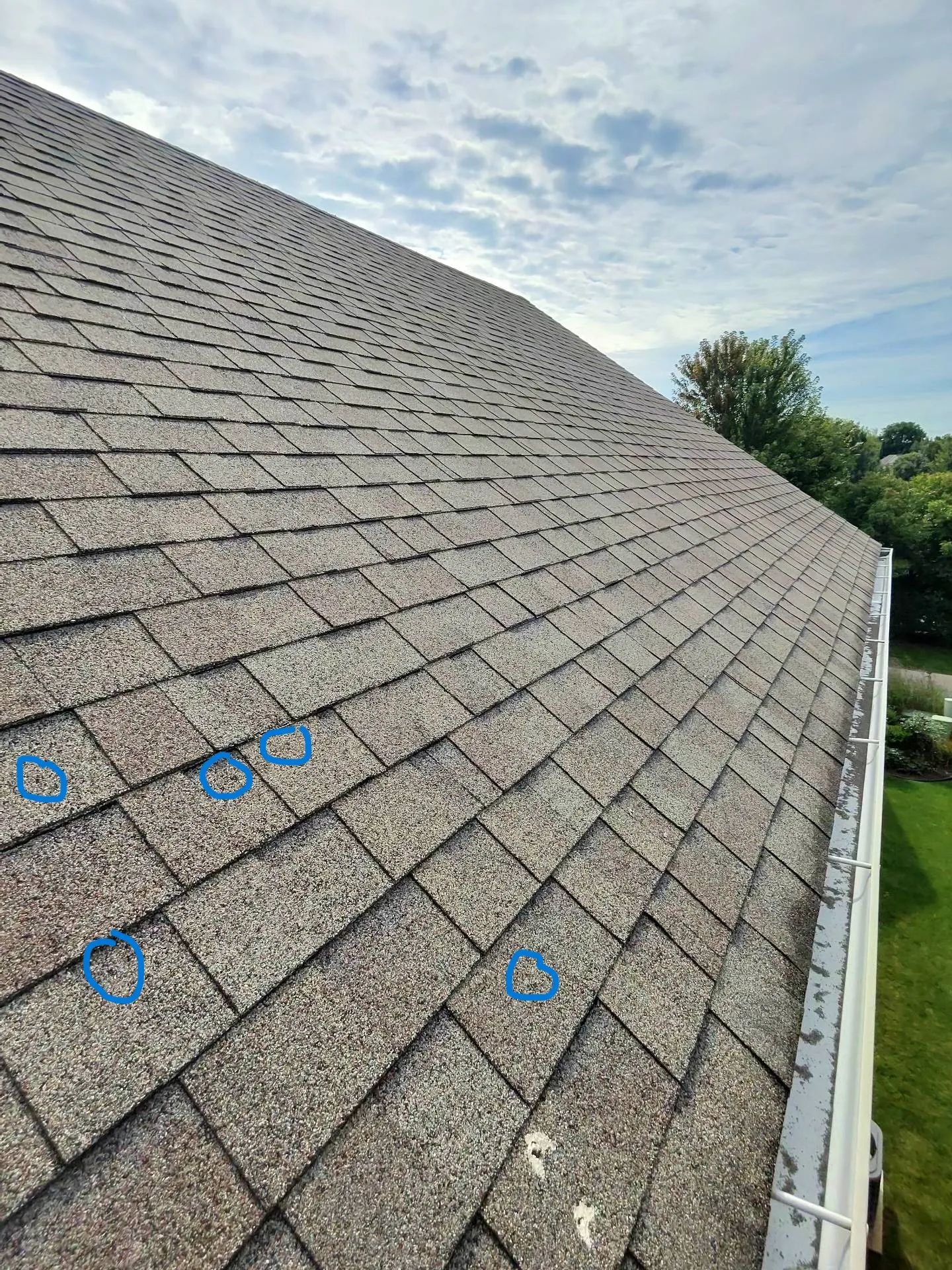Left: Asphalt shingle roof with multiple hail impact points circled during a professional inspection