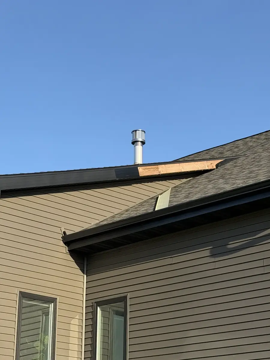 Wind-damaged fascia at roofline peak of Wisconsin home with exposed wood decking