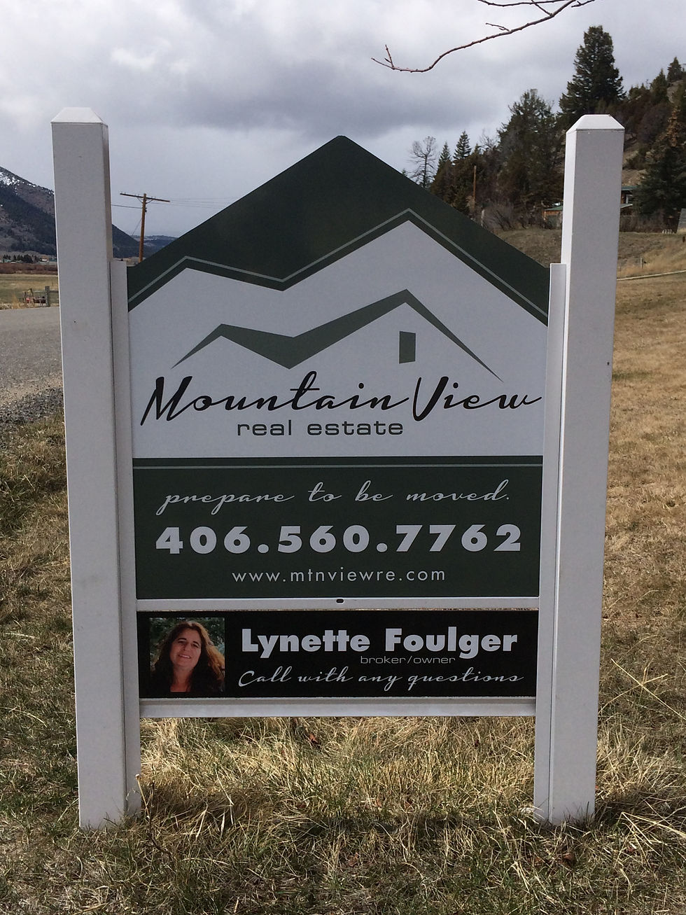 High angle view of a house with a "For Sale" sign in the front yard