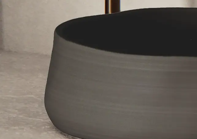 Minimalist dark grey round coffee table with black top, modern design.