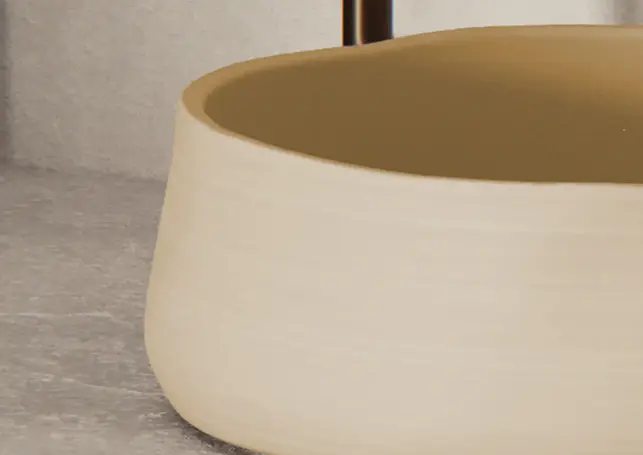 Beige ceramic bowl with an earthy yellow interior, on light surface.