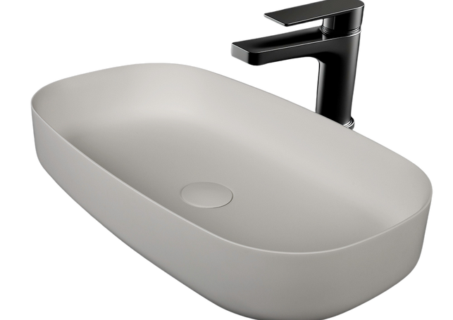 Oval light grey basin and modern black faucet on black background.