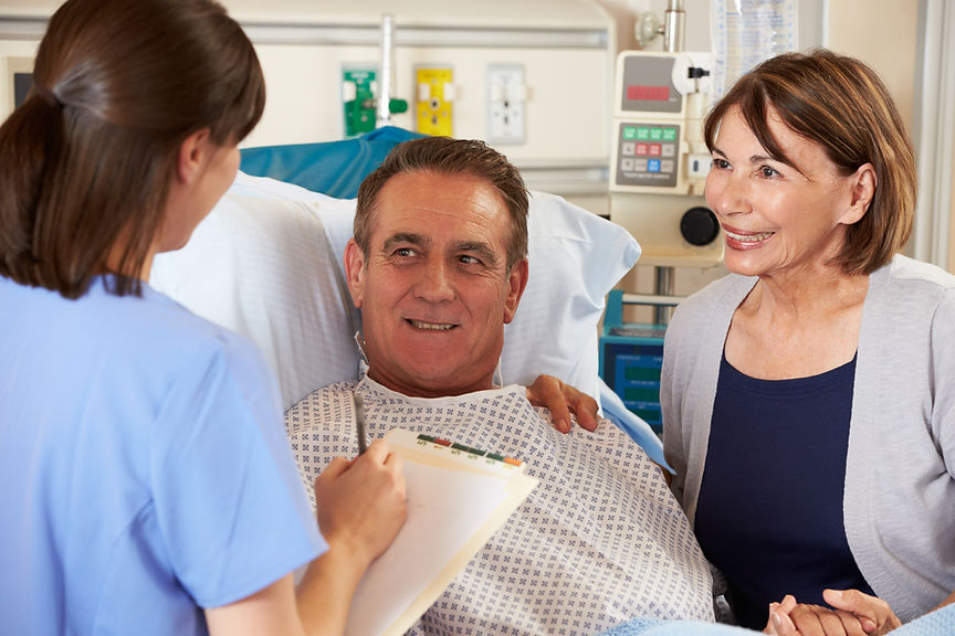 Speech therapist counseling stroke patient and wife at bedside