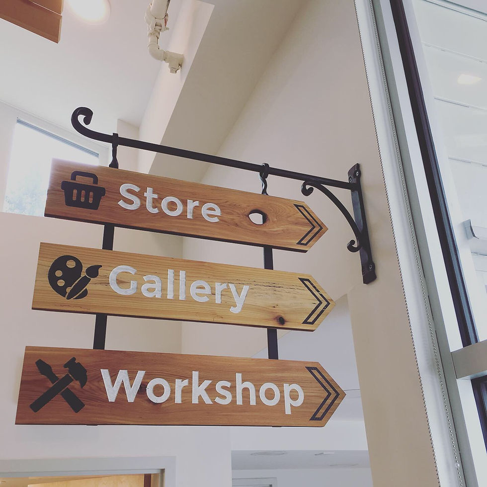 The Village wayfinding . Cedar etched and painted with cast iron bracket